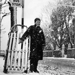 Young Andrew Burley stands in the queue for the bus with his sledge during heavy snowfall Young Andrew Burley stands in the queue for the bus with his sledge during heavy snowfall