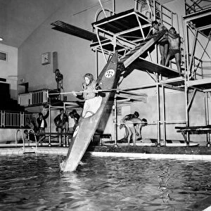Young boy takes a canoe of a 10 feet high diving board at Bournemouth swimming pool