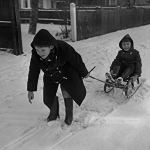Two young boys enjoying the snow in Cambridge. January 1960