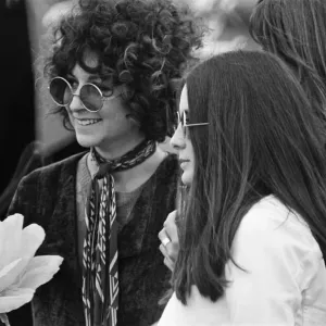 A young couple, with large flower and fashionable sunglasses at The Windsor Jazz Festival A young couple, with large flower and fashionable sunglasses at The Windsor Jazz Festival
