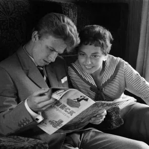 A young couple on a train, reading a copy of Photoplay magazine A young couple on a train, reading a copy of Photoplay magazine