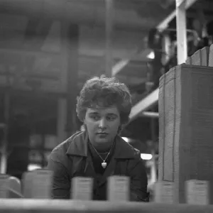 A young female employee checks that the machine has correctly filled A young female employee checks that the machine has correctly filled
