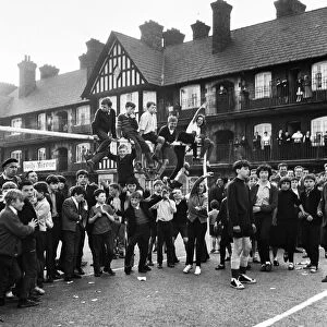 Young football fans sits on top of the crossbar following the conclusion of the Eldon