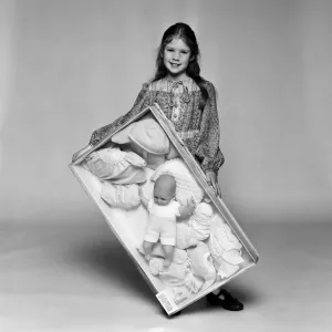 A Young Girl with Doll and Clothes Print, December 1980