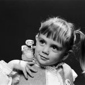 A young girl holding an E. T. from the film E. T. the Extra-Terrestrial. 5th December 1982 A young girl holding an E. T. from the film E. T. the Extra-Terrestrial. 5th December 1982