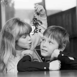 A young Girl with mistletoe attempts to kiss a young lad. 23rd December 1985 A young Girl with mistletoe attempts to kiss a young lad. 23rd December 1985