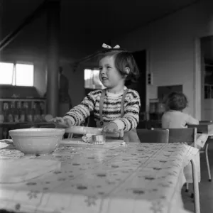 Young girl rolling out dough in cookery class at Cookham Nursery School