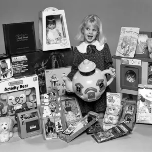 A young girl with a selection of childrens toys for Christmas. 6th December 1984
