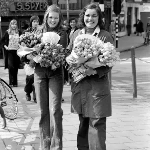 Two young girls of Amsterdam holding bunches of tulips during the season May 1975 Two young girls of Amsterdam holding bunches of tulips during the season May 1975