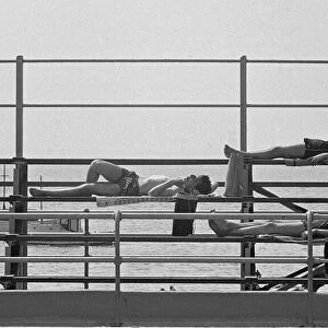 Four young lads sun bathing after taking a dip in the sea at Southend, Essex