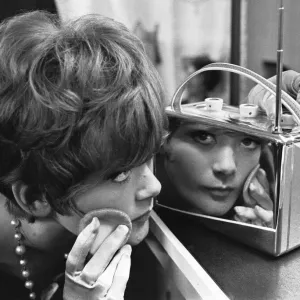 Una joven señorita utiliza una radio encasillada en cromado en la Exhibición Nacional de Radio de 1961 para tocar su.