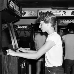 Young people playing video games in an amusement arcade in London. 13th July 1983