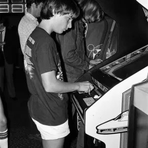 Young people playing video games in an amusement arcade in London. 13th July 1983