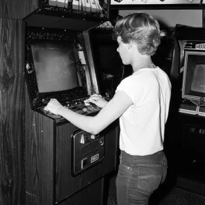 Young people playing video games in an amusement arcade in London. 13th July 1983