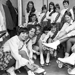 Young roller skaters lace up their boots and chat back stage as they prepare to take part