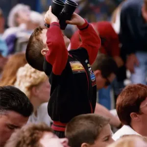 A young spectator looks through a pair of binoculars at an air display at the Sunderland A young spectator looks through a pair of binoculars at an air display at the Sunderland