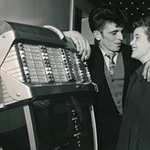 A young trendy couple select their song on the Juke box as they prepare to get married