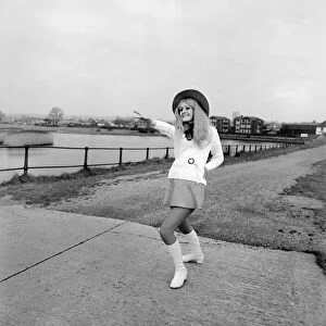 Young woman wearing a hat, mini skirt and knee high boots on the sea front at Southampton