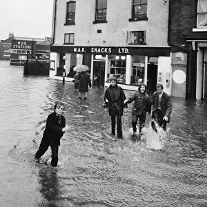 Youngsters find crossing the road difficult in a flooded Macclesfield street after heavy