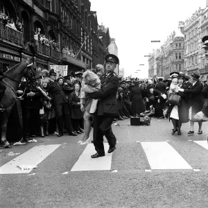 10 July 1964 An fan injured in the crush is helped away as crowds await the arrival of