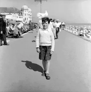Shadow Prints: 10 year old Alan Barker with a friendly pigeon on his head as he walks along