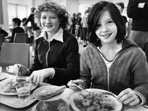 00122 Prints: 13 year old Helen Boldre and Gillian Cook tuck into their school dinners