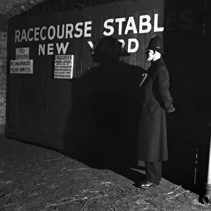 Shadows Prints: 1952 Grand National. A policeman on guard outside new yard stables at Aintree