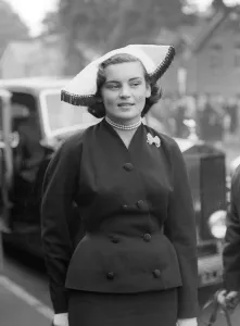 00197 Prints: 1953 Clothing Ascot Fashion Mrs W Ofner wearing a white fur hat with navy blue