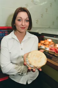 21 year old barmaid Sarah Pilcher holds up a steak and kidney pie in a fish and chip shop