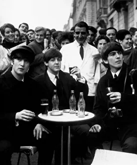 3 Beatles - John, Paul and George enjoy a glass of coca cola at a street cafe in Paris