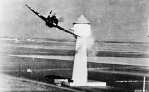 An 8th U. S. A. A. F. P-47 attacks a flak tower at a German aerodrome in occupied France