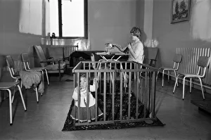 Childcare Prints: 9 month old Jane Turnock plays happily in her play pen as her mothers works away in