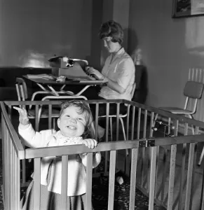 01152 Prints: 9 month old Jane Turnock plays happily in her play pen as her mothers works away in
