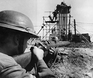 To the accompaniment of rifle fire British Army troops undergo a hardening course in