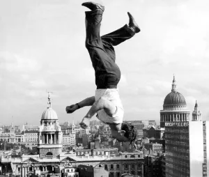 Stuntman Prints: Acrobat Frank Paulo jumps upside down on a trampoline on the roof of the GPO building in