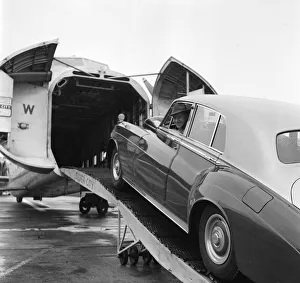 Actor Alec Guinness loading his Bently onto an aircraft bound for France where he will