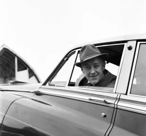 Actor Alec Guinness loading his Bently onto an aircraft bound for France where he will