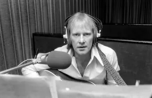 Headphones Prints: Actor Dennis Waterman, seen here in the recording studio with his guitar. December 1975