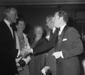 00138 Prints: Actor Kenneth More shakes hands with Mrs E Daniels of Portsmouth who was a survivor of