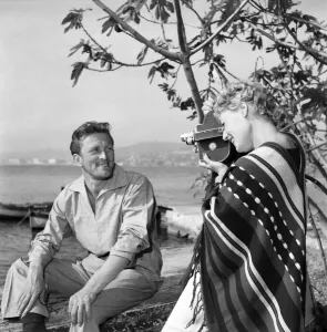 Actor Kirk Douglas having his photograph taken by starlet. D3118-026