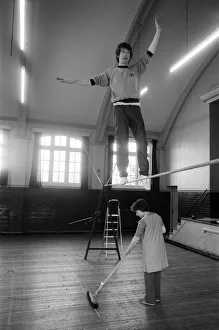 Tightrope Prints: Actor Michael Crawford works out on the high wire with a charlady sweeping the floor