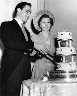 Cutting Prints: Actor Richard Todd with his bride Catherine Bogle cutting the cake on their wedding day