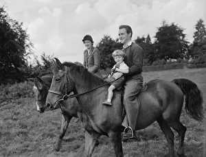 Actor Richard Todd playing with his son Peter on horseback at home