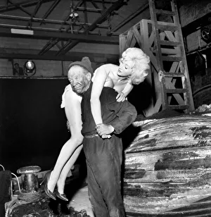 Actor Sidney James carrying Liz Fraser on set at Twickenham Studios were they are making