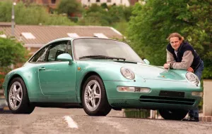Harley Davidson Prints: Actor Simon Weir poses by the Porsche Targa 911 car May 1997