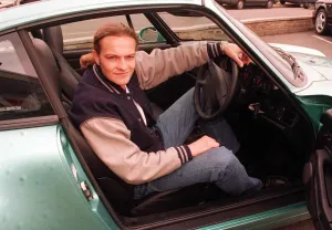 Harley Davidson Prints: Actor Simon Weir poses sitting in the driving seat of the Porsche Targa 911 car May 1997