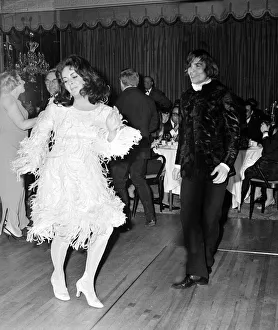 Actress Elizabeth Taylor dancing with Nureyev wearing an unusual feathered dress