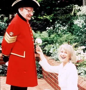 Kneeling Prints: Actress Helen Mirren May 1994 at the Chelsea Flower show with a pensioner