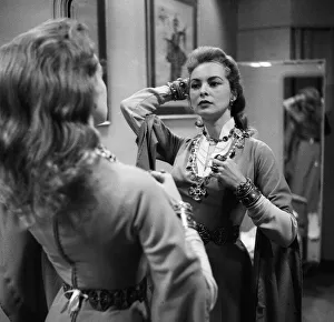 Actress Janet Leigh looks at her reflection in the mirror at a costume fitting for