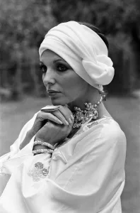 Actress Joan Collins modelling outfits that she will wear on a trip to Tokyo to judge a